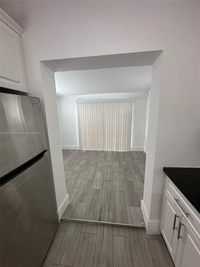 corridor featuring baseboards and wood tiled floor