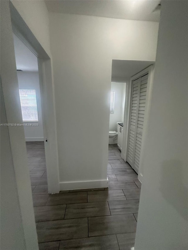 corridor with wood finish floors and baseboards