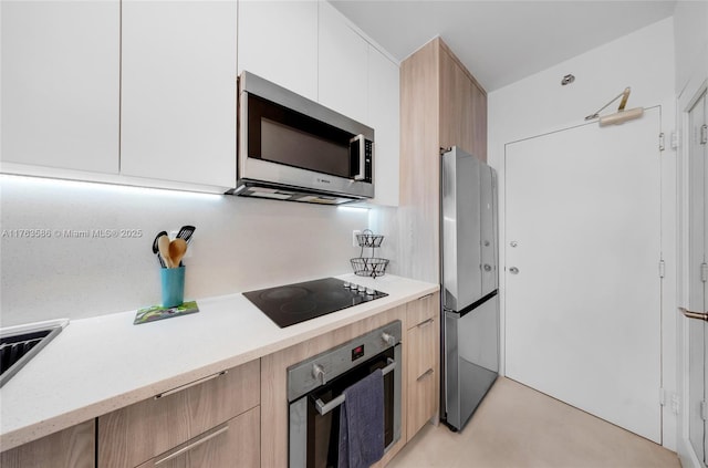 kitchen featuring modern cabinets, light brown cabinets, and stainless steel appliances