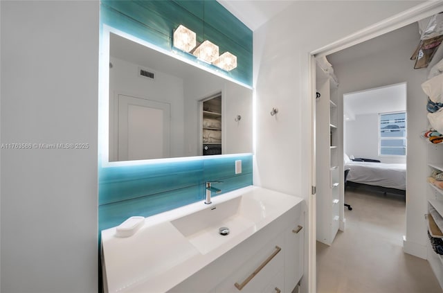 bathroom featuring vanity, visible vents, and ensuite bathroom