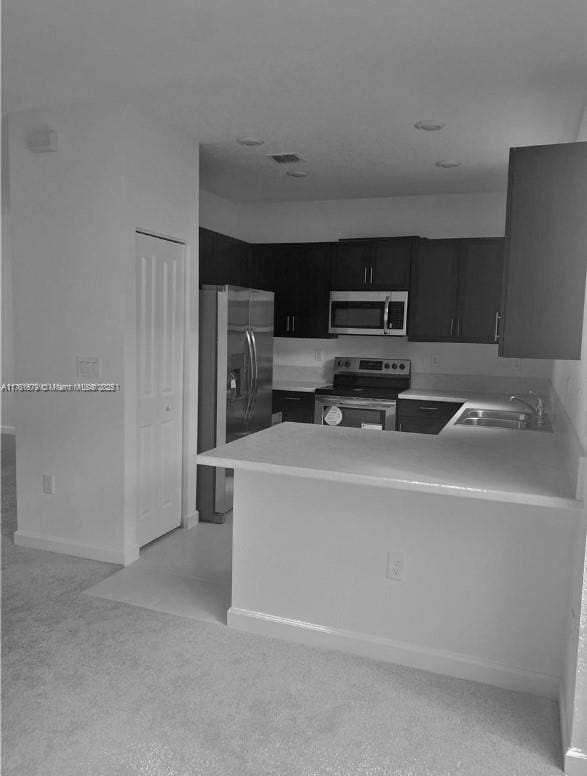 kitchen featuring visible vents, a sink, light countertops, appliances with stainless steel finishes, and dark cabinets