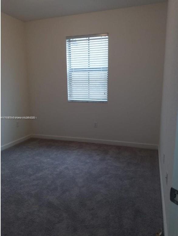 empty room featuring baseboards and carpet floors