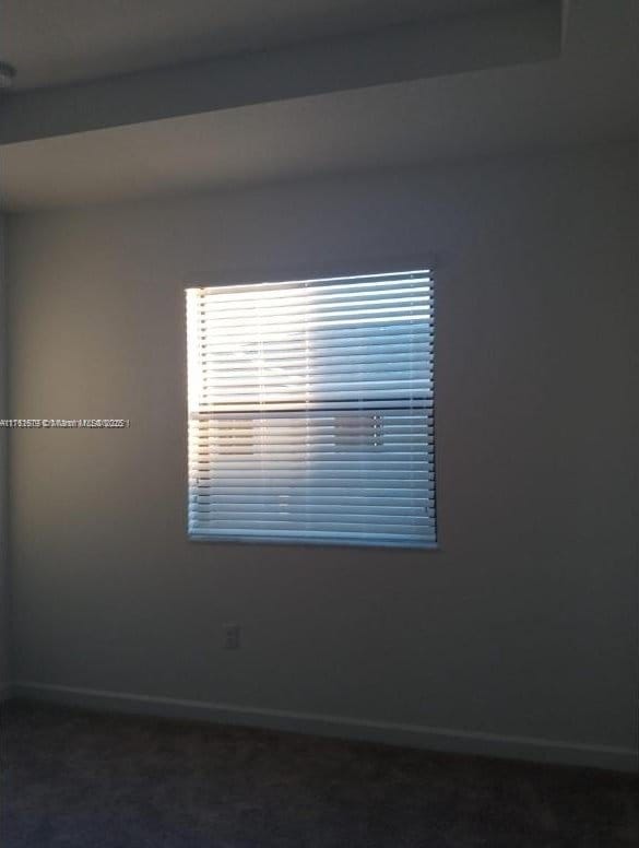 carpeted spare room with baseboards