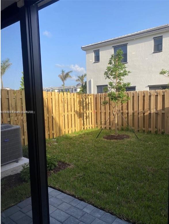 view of yard with cooling unit and fence