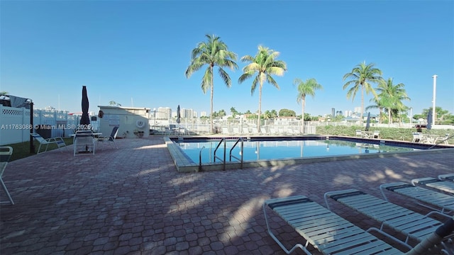 pool with a patio and fence