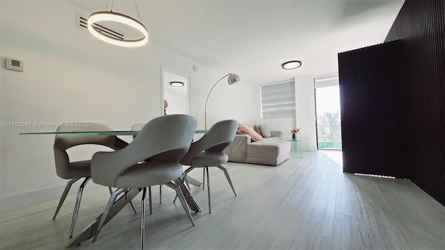 dining space featuring expansive windows and light wood finished floors