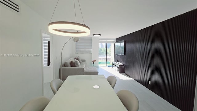 dining space featuring an accent wall and visible vents