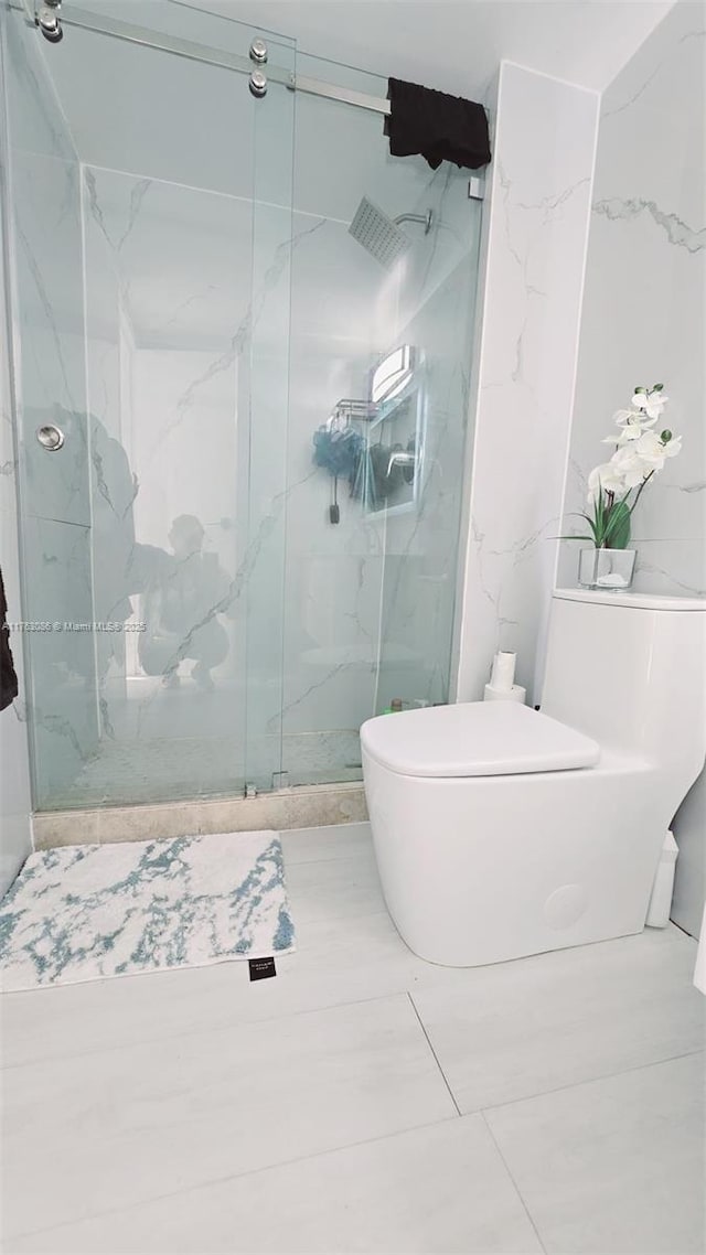 full bath featuring toilet and a marble finish shower