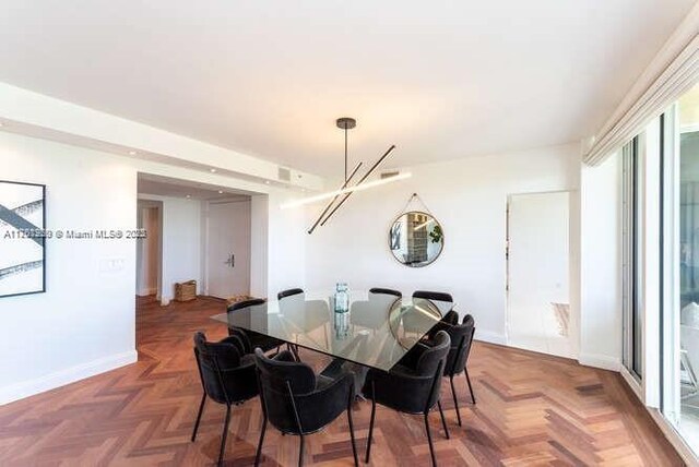 dining area with baseboards and a notable chandelier