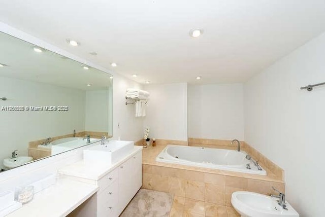 bathroom with recessed lighting, a bidet, a garden tub, and vanity