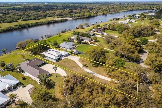 drone / aerial view featuring a forest view and a water view