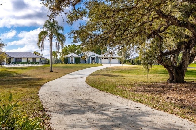 view of front facade with an attached garage, concrete driveway, and a front lawn