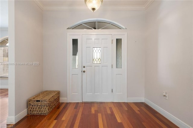 foyer entrance featuring baseboards, wood finished floors, and ornamental molding