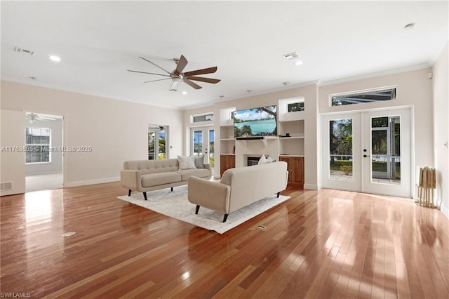 living room featuring visible vents, a ceiling fan, hardwood / wood-style floors, french doors, and crown molding