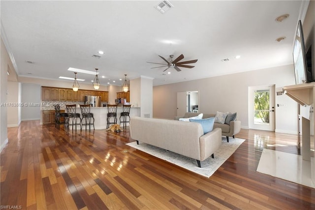 living area with visible vents, baseboards, hardwood / wood-style floors, recessed lighting, and a ceiling fan