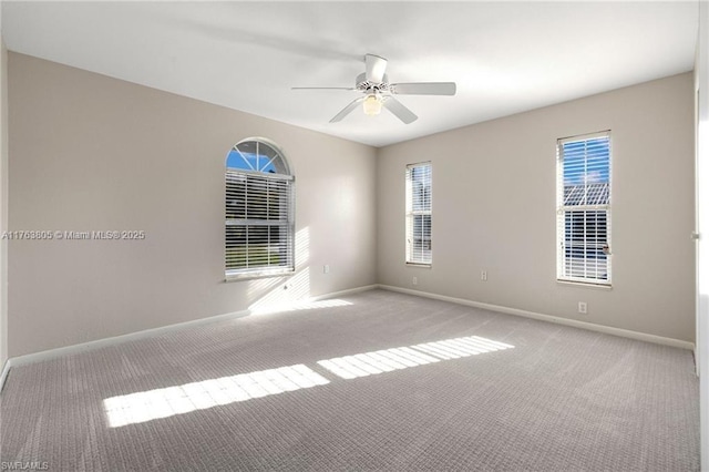 spare room with carpet flooring, ceiling fan, and baseboards