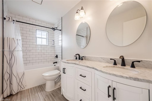 full bathroom featuring a sink, shower / tub combo with curtain, double vanity, and toilet