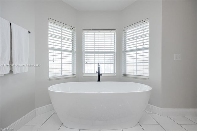 bathroom with a soaking tub and baseboards