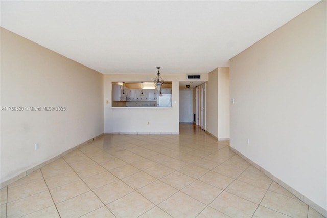 empty room with visible vents, baseboards, and light tile patterned flooring