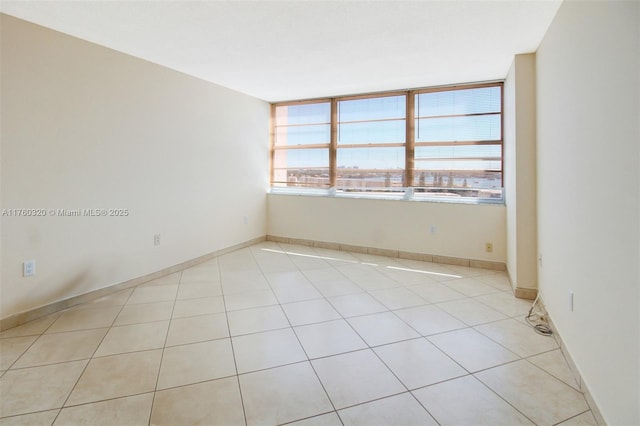 spare room with light tile patterned floors and baseboards