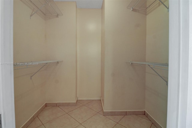 walk in closet with light tile patterned floors