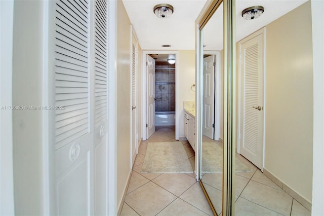 corridor with light tile patterned flooring and baseboards