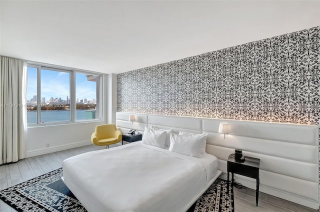 bedroom featuring a view of city, baseboards, and wood finished floors