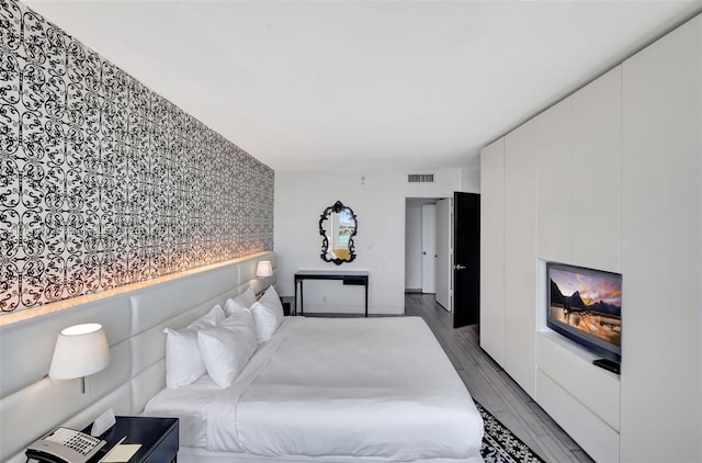 bedroom featuring visible vents and wood finished floors