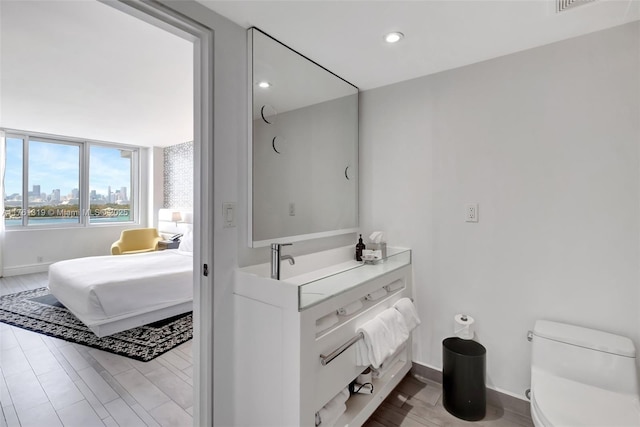 bathroom featuring recessed lighting, toilet, a view of city, and baseboards