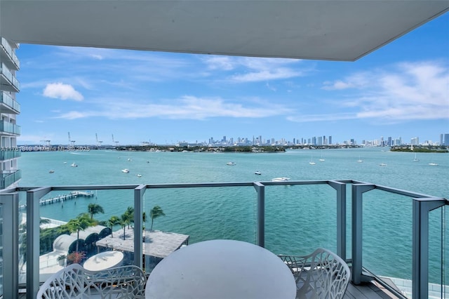 balcony featuring a water view and a city view