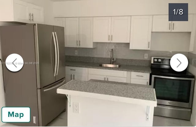 kitchen featuring white cabinets, appliances with stainless steel finishes, and a sink