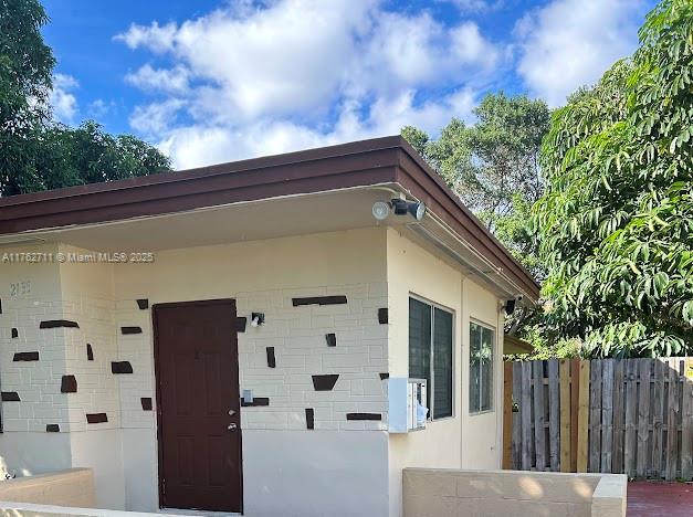 exterior space featuring stucco siding and fence