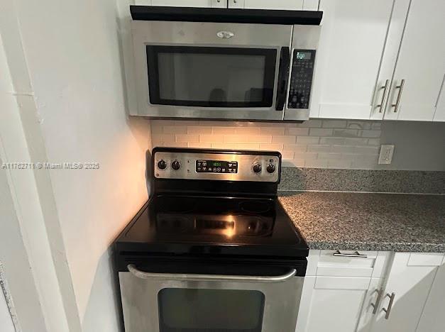 kitchen featuring tasteful backsplash, white cabinetry, and stainless steel appliances