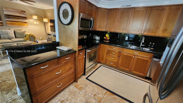 kitchen with visible vents, ornamental molding, brown cabinets, stainless steel appliances, and a sink