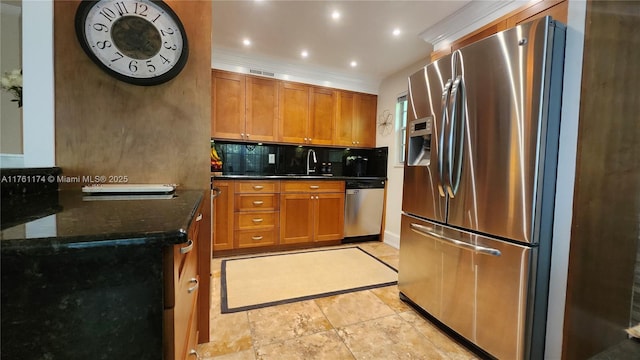 kitchen with brown cabinetry, backsplash, stainless steel appliances, and a sink