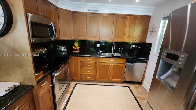 kitchen featuring brown cabinets, stainless steel appliances, and a sink