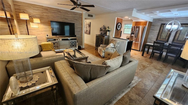 living area featuring an accent wall, a ceiling fan, visible vents, and baseboards