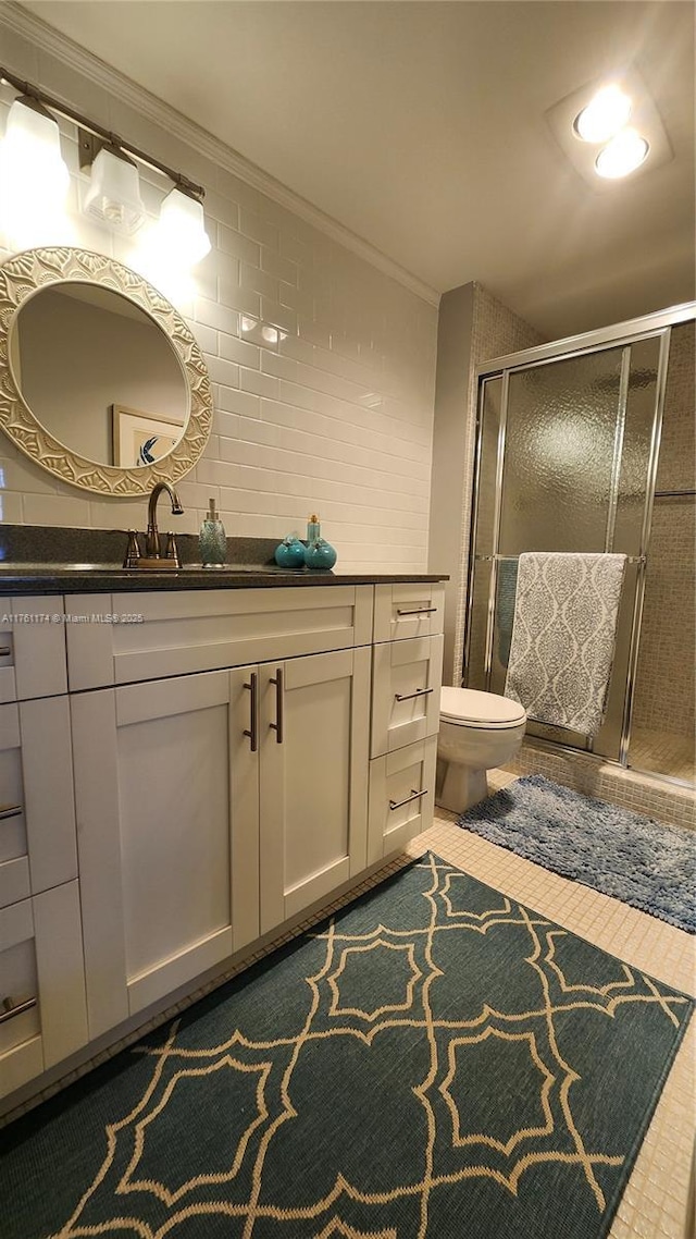 bathroom featuring a shower stall, vanity, toilet, and ornamental molding