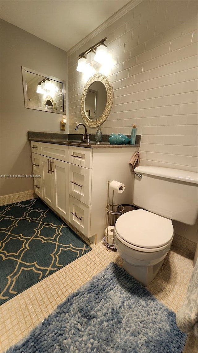 half bath with baseboards, toilet, and vanity