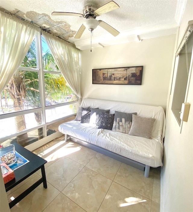 living area featuring a textured ceiling, ceiling fan, and tile patterned flooring