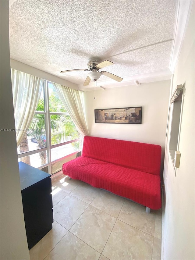 living area featuring tile patterned floors, ceiling fan, and a textured ceiling
