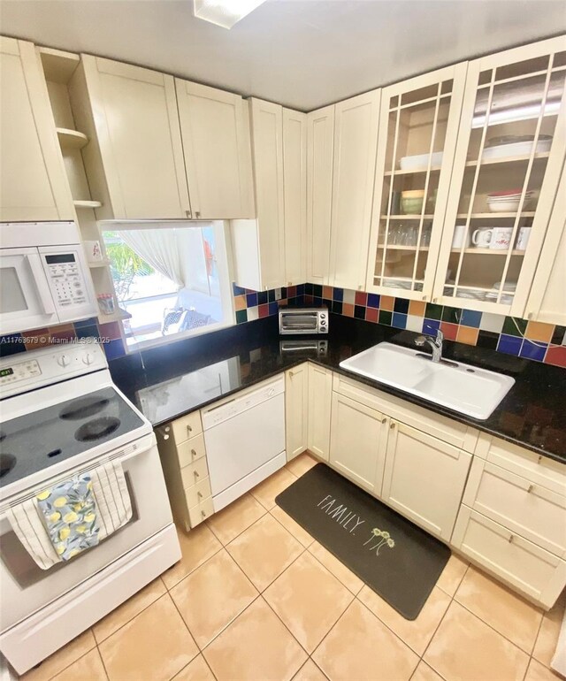 kitchen with white appliances, light tile patterned floors, open shelves, backsplash, and a sink