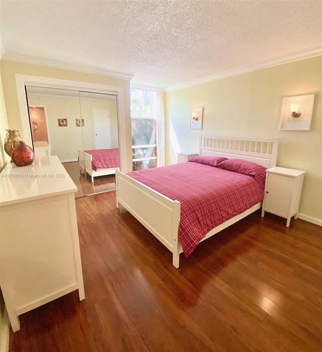 bedroom featuring a textured ceiling, wood finished floors, and ornamental molding