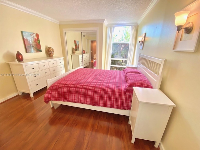 bedroom with baseboards, wood finished floors, a textured ceiling, and ornamental molding