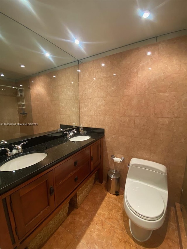 full bathroom featuring double vanity, tile walls, and a sink
