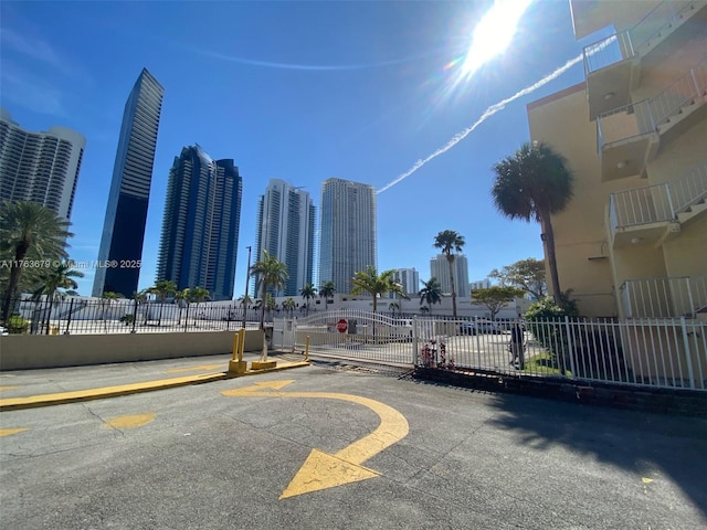 view of road with a view of city, a gate, a gated entry, and traffic signs
