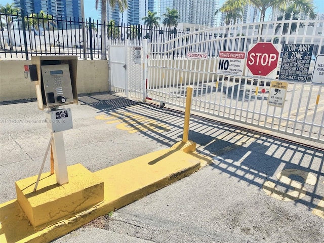view of gate with a view of city and fence