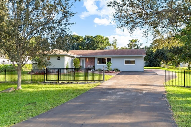 ranch-style house with a fenced front yard, stucco siding, concrete driveway, and a front lawn