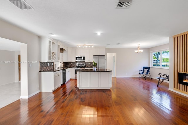 13390 SW 26th St, Davie, FL 33325 - kitchen with stainless steel appliances, tasteful backsplash, white cabinets, and dark wood finished floors