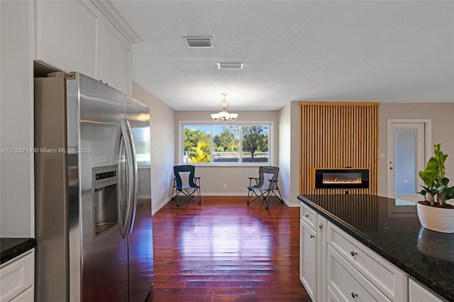 kitchen featuring visible vents, an inviting chandelier, stainless steel fridge with ice dispenser, dark wood-type flooring, and white cabinetry